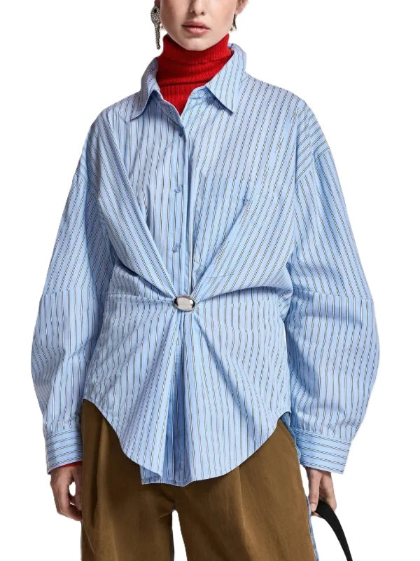 Bluse ESSENTIEL ANTWERP Kreative in blau. Gestreifte Bluse aus Baumwolle mit lässiger Oversized-Silhouette, tief angesetzten Schultern und voluminösen Ärmeln. Abgerundete Nahtpartien, eine Brusttasche, Knopfleiste mit Knopfmanschetten und eine abnehmbare Brosche.