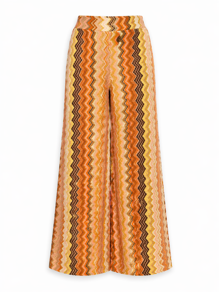 Hose Pho Firenze in orange und braun. Diese Sommerhose überzeugt mit einem besonderen Chevron-Muster und einer modernen, weiten Silhouette. Der angenehme Stretchbund sorgt für hohen Tragekomfort, während das feine Glitzergarn dem Design eine edle, lebendige Note verleiht. Zwei seitliche Hosentaschen unterstreichen die lässige Ausstrahlung. 
