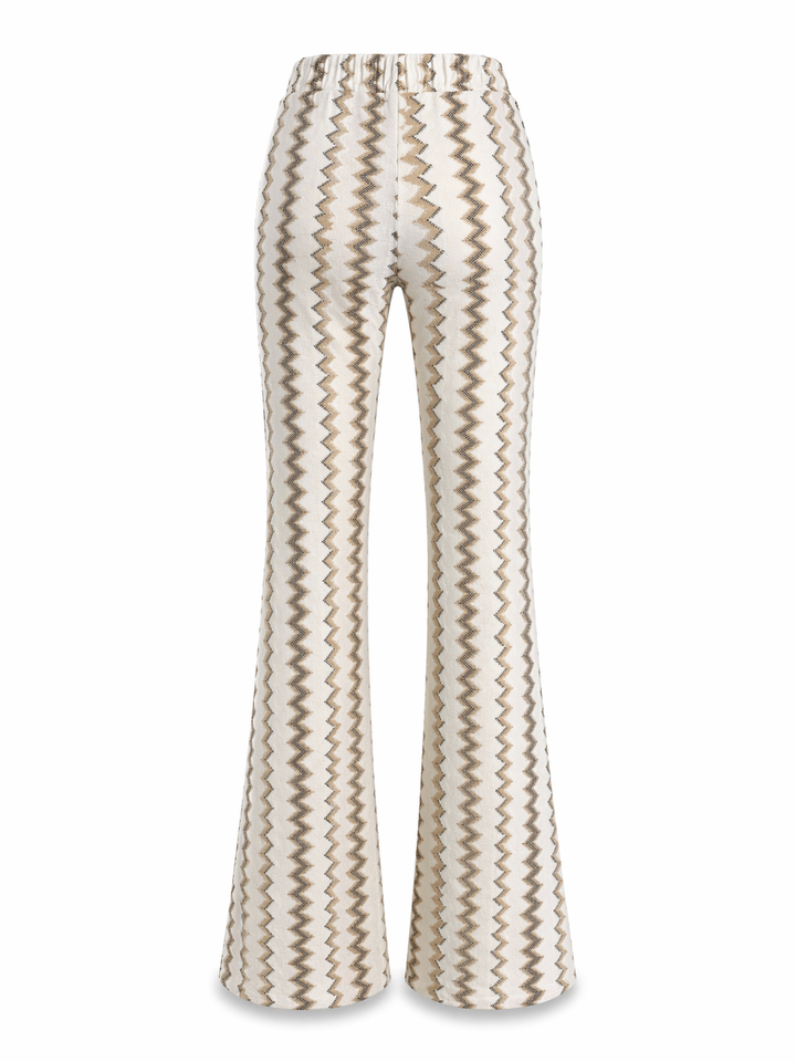 Hose Pho Firenze in gold und weiß. Lange und bezaubernde Hose im Zickzack-Muster. Die Hose hat einen Gummizug und Taschen. Sie hat einen kleinen Kick. Das zarte Glitzergarn wirkt besonders edel und feminin. Wir haben auch das passende Oberteil dazu, so dass der Look wie ein Overall aussieht.