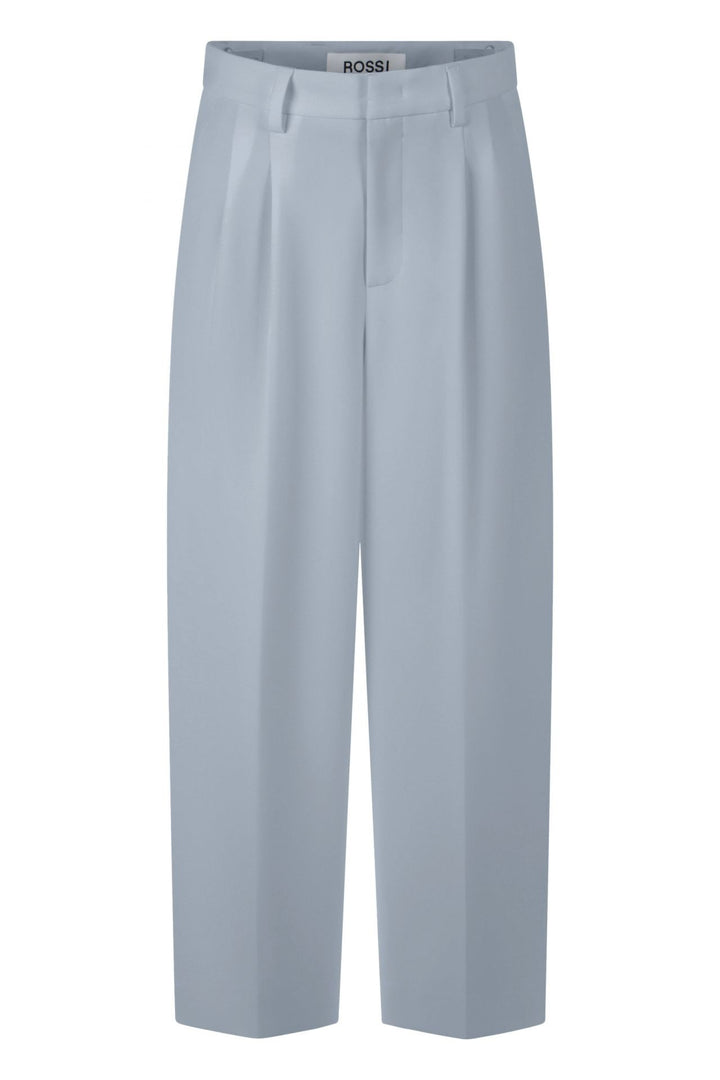 Hose Rossi Noa Crop. Coole Hose in verkürzter Form. Die Hose hat Bundfalten und einen verstellbaren Innenbund. Sie ist High-Waist geschnitten und hat ein verkürztes Bein. Der leichte O-Shape verleiht der Hose einen modernen Look. Die Hose hat schräge Eingriffstaschen und eine Leistentasche auf der Rückseite in hellblau.