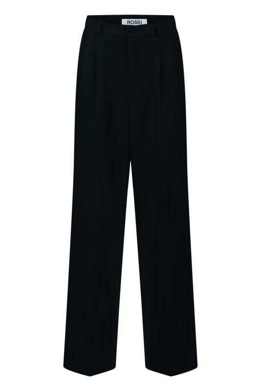 Hose Rossi Noa. Die lässige Hose von Rossi hat eine Bundfalte und seitliche Eingriffstaschen. Sie hat eine lange Beinlänge und ist am Oberschenkel lässig geschnitten. Die Hose kann man auf der Innenseite mit Knöpfen verstellen. Die Hose hat eine höhere Leibhöhe in marine