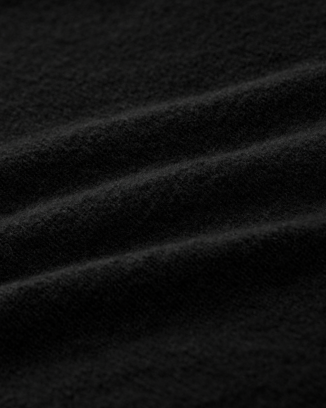 Strickjacke LUCELLE von Luren aus Kaschmir mit weichem Feinstrick, Umlegekragen und leicht verkürzter A-Linien-Silhouette. Die Strickjacke hat eine verdeckte Knopfleiste und ist schwarz.