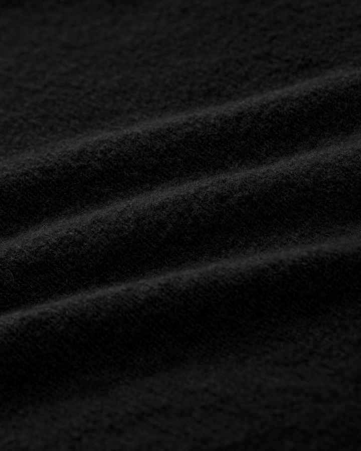 Strickjacke LUCELLE von Luren aus Kaschmir mit weichem Feinstrick, Umlegekragen und leicht verkürzter A-Linien-Silhouette. Die Strickjacke hat eine verdeckte Knopfleiste und ist schwarz.