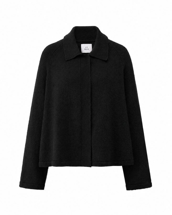 Strickjacke LUCELLE von Luren aus Kaschmir mit weichem Feinstrick, Umlegekragen und leicht verkürzter A-Linien-Silhouette. Die Strickjacke hat eine verdeckte Knopfleiste und ist schwarz.