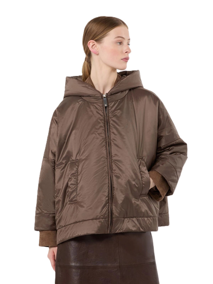 Jacke S Max Mara MTCFIORE in braun. Kurze, wattierte Jacke mit tiefen Seitenschlitzen, die sich mit Druckknöpfen öffnen lassen. Die Jacke besteht aus einer wasserabweisenden Canvas-Ware. Sie ist oversized geschnitten. Die Jacke hat einen Reißverschluss und weit überschnittene Schultern. Sie hat eine Kapuze und feminine 3/4 Ärmel.