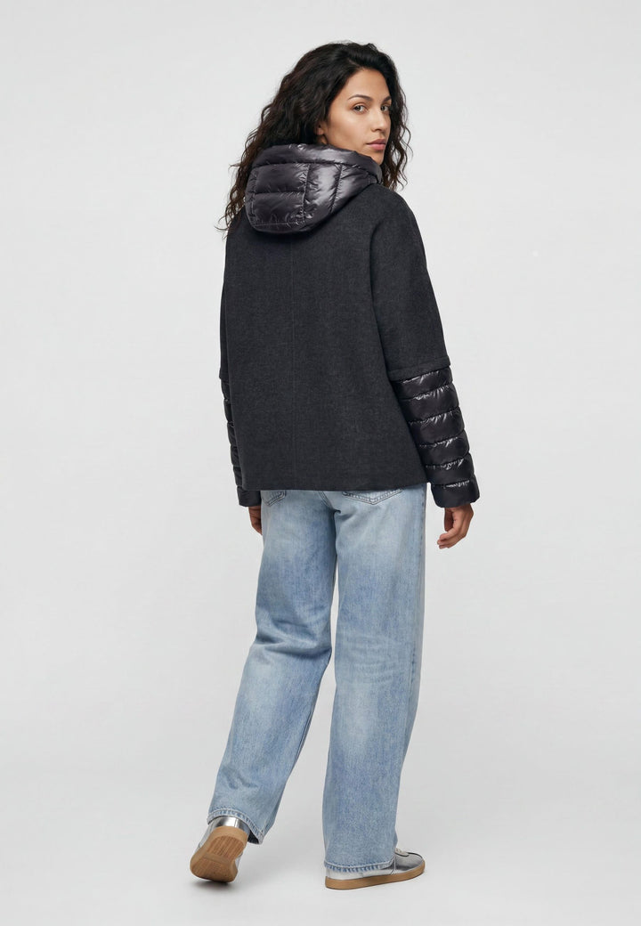Jacke Milestone MSAzalea in anthrazit. Schöne Jacke mit zweierlei Stoffmix. Die Jacke besteht aus Wolle Doubleface und Stepp. Sie hat eine leichte A-Form und einen dekorativen Stehkragen aus Strick. Die Jacke hat eine abnehmbare Kapuze aus Nylon mit Tunnelzug. Die Ärmel sind aus Nylon gesteppt. Sie hat einen Metall-Reißverschluss in der vorderen Mitte und Eingriffstaschen.