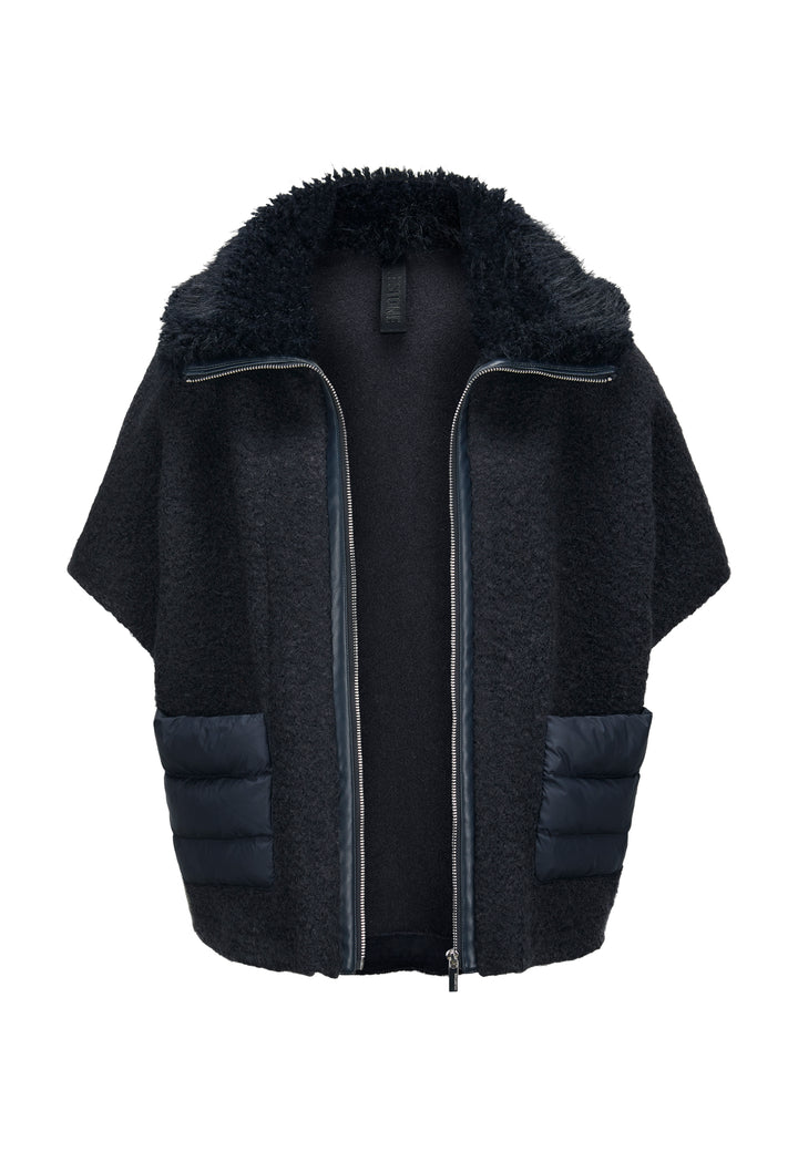 Jacke Milestone MSGloria in nachtblau. Cape mit überschnittenen 3/4 Ärmeln. Sie wurde aus einer gekochten Wolloptik mit Nylon-Patches gefertigt. Der Kragen besteht aus einem hübschen Curly-Fakefur. Die Jacke hat einen Metallreißverschluss in der vorderen Mitte und aufgesetzten Taschen aus Nylonstepp.