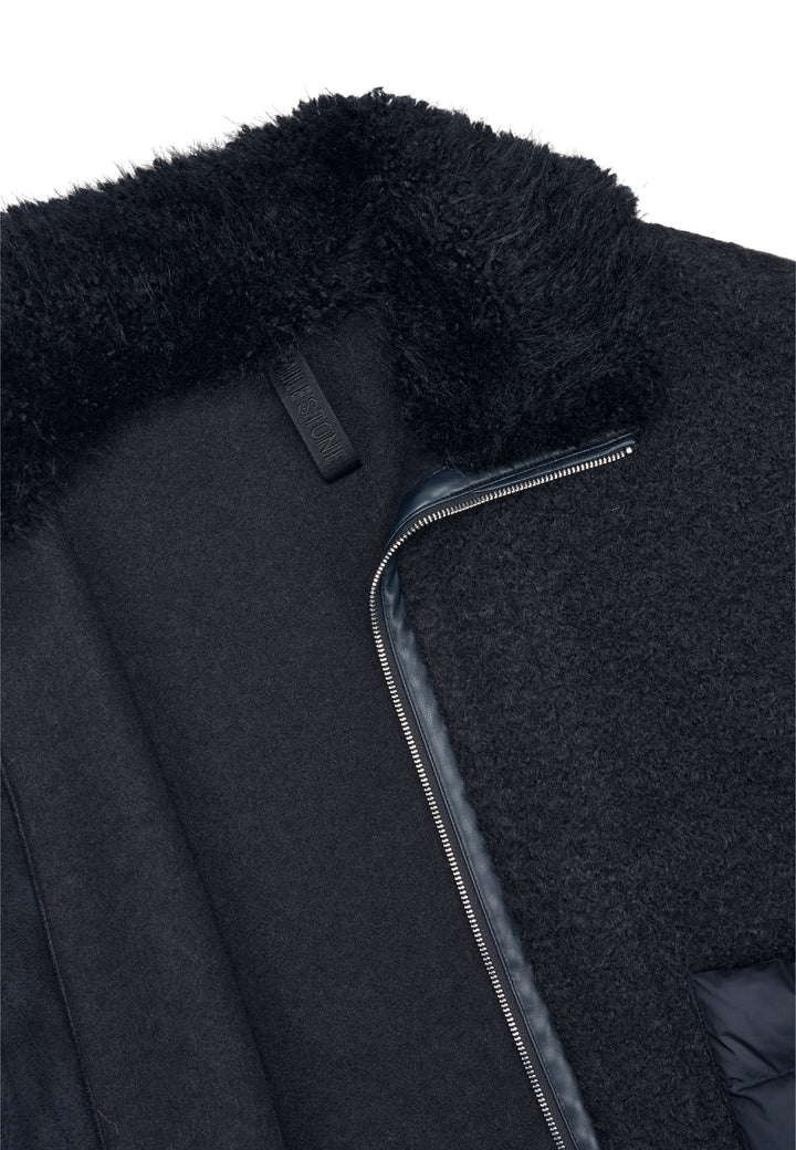 Jacke Milestone MSGloria in nachtblau. Cape mit überschnittenen 3/4 Ärmeln. Sie wurde aus einer gekochten Wolloptik mit Nylon-Patches gefertigt. Der Kragen besteht aus einem hübschen Curly-Fakefur. Die Jacke hat einen Metallreißverschluss in der vorderen Mitte und aufgesetzten Taschen aus Nylonstepp.