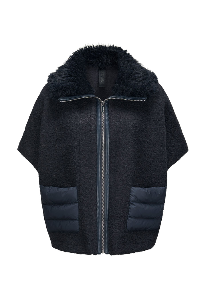 Jacke Milestone MSGloria in nachtblau. Cape mit überschnittenen 3/4 Ärmeln. Sie wurde aus einer gekochten Wolloptik mit Nylon-Patches gefertigt. Der Kragen besteht aus einem hübschen Curly-Fakefur. Die Jacke hat einen Metallreißverschluss in der vorderen Mitte und aufgesetzten Taschen aus Nylonstepp.