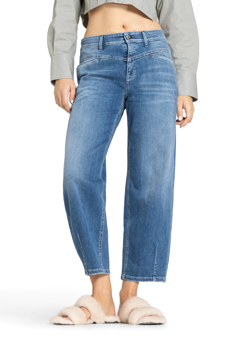 Cambio Jeans Elin in blau. Coole Jeans in blau mit Stitching. Die Jeans hat schräge Einschubtaschen auf der Vorderseite und Gesäßtaschen. Die Form ist leicht ballonförmig, das heißt, dass die Jeans nach unten hin schmäler zuläuft. Am Saum hat sie Ziernähte. Die Jeans hat eine angenehme leichte Ware