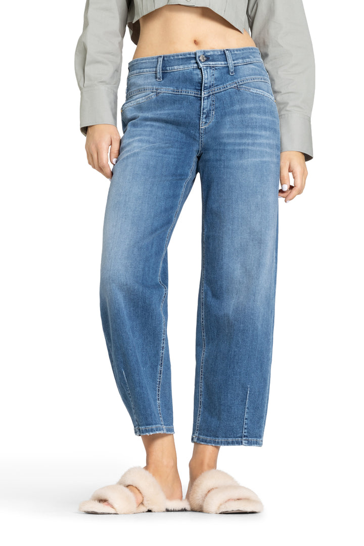 Cambio Jeans Elin in blau. Coole Jeans in blau mit Stitching. Die Jeans hat schräge Einschubtaschen auf der Vorderseite und Gesäßtaschen. Die Form ist leicht ballonförmig, das heißt, dass die Jeans nach unten hin schmäler zuläuft. Am Saum hat sie Ziernähte. Die Jeans hat eine angenehme leichte Ware