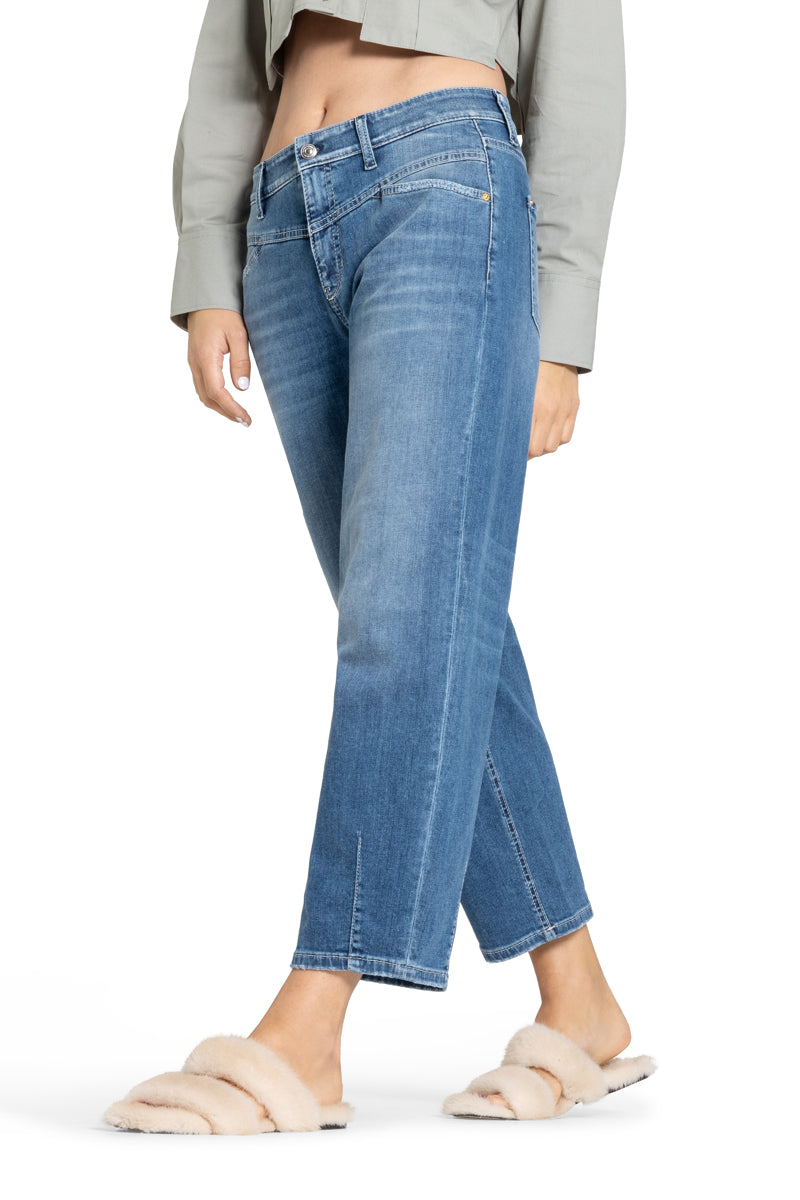 Cambio Jeans Elin in blau. Coole Jeans in blau mit Stitching. Die Jeans hat schräge Einschubtaschen auf der Vorderseite und Gesäßtaschen. Die Form ist leicht ballonförmig, das heißt, dass die Jeans nach unten hin schmäler zuläuft. Am Saum hat sie Ziernähte. Die Jeans hat eine angenehme leichte Ware