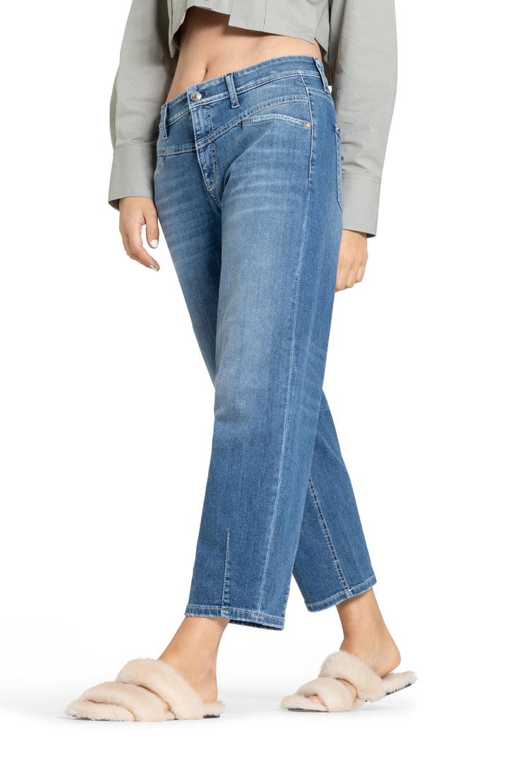 Cambio Jeans Elin in blau. Coole Jeans in blau mit Stitching. Die Jeans hat schräge Einschubtaschen auf der Vorderseite und Gesäßtaschen. Die Form ist leicht ballonförmig, das heißt, dass die Jeans nach unten hin schmäler zuläuft. Am Saum hat sie Ziernähte. Die Jeans hat eine angenehme leichte Ware