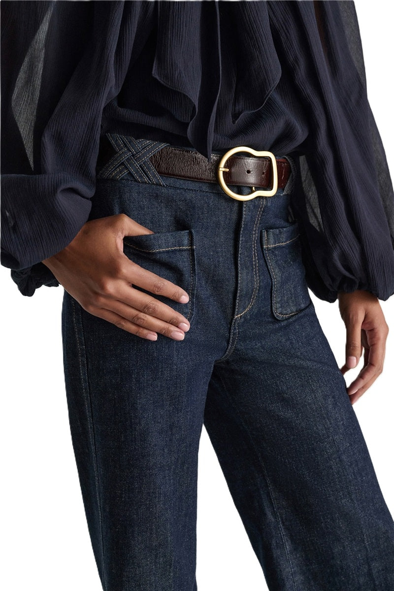Jeans Dorothee Schumacher DENIM LOVE Pants in dark denim. Die ausgestellte dunkelblaue Jeans besticht durch ihre aufgesetzten Taschen vorne und braided Details am Bund. Dadurch bekomt die Jeans einen modernen Retro-Look. Der schmale Schnitt wird durch einen Signature-Knopf abgerundet. Die Jeans hat einen Kick und Bügelfalten. Auf der Rückseite befinden sich Pattentaschen.