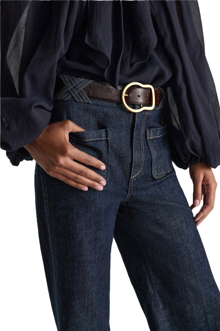 Jeans Dorothee Schumacher DENIM LOVE Pants in dark denim. Die ausgestellte dunkelblaue Jeans besticht durch ihre aufgesetzten Taschen vorne und braided Details am Bund. Dadurch bekomt die Jeans einen modernen Retro-Look. Der schmale Schnitt wird durch einen Signature-Knopf abgerundet. Die Jeans hat einen Kick und Bügelfalten. Auf der Rückseite befinden sich Pattentaschen.