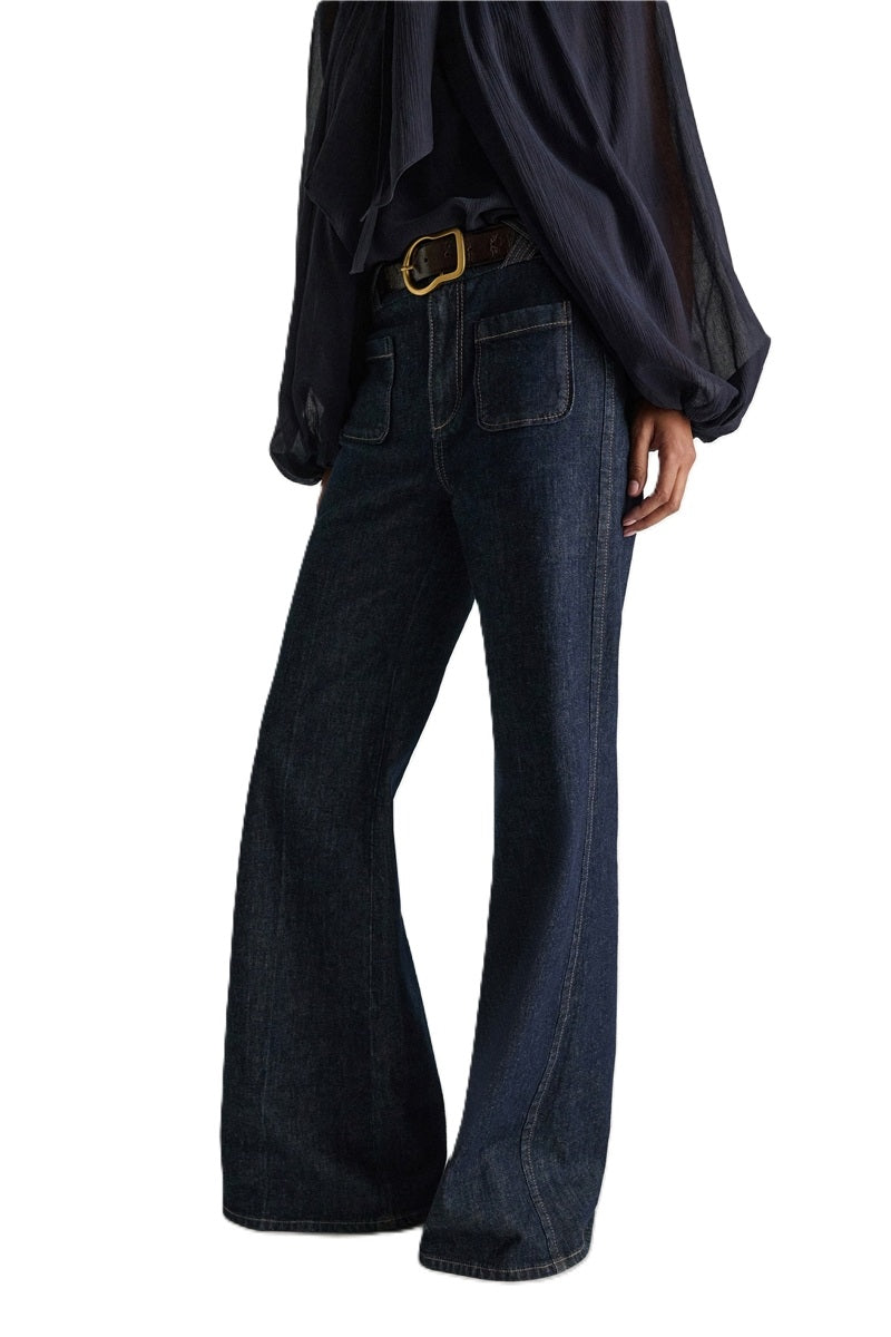 Jeans Dorothee Schumacher DENIM LOVE Pants in dark denim. Die ausgestellte dunkelblaue Jeans besticht durch ihre aufgesetzten Taschen vorne und braided Details am Bund. Dadurch bekomt die Jeans einen modernen Retro-Look. Der schmale Schnitt wird durch einen Signature-Knopf abgerundet. Die Jeans hat einen Kick und Bügelfalten. Auf der Rückseite befinden sich Pattentaschen.