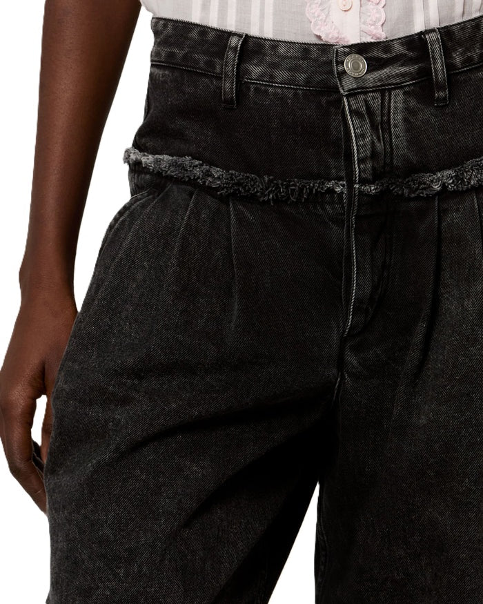 Jeans Isabel Marant Iniza Pants in black denim. Jeans aus weich fallendem Baumwolldenim in verwaschenem Schwarz. Der Schritt ist weit und in Falten gelegt. Bundfalten auf der Vorderseite. Verdeckter Reißverschluss. Der Metallknopf hat eine "Isabel Marant" Gravur. Die Jeans hat schräge seitliche Eingriffstaschen und Paspeltaschen auf der Rückseite. Die Taille ist betont und hat einen Einsatz mit Fransenabschluss. 