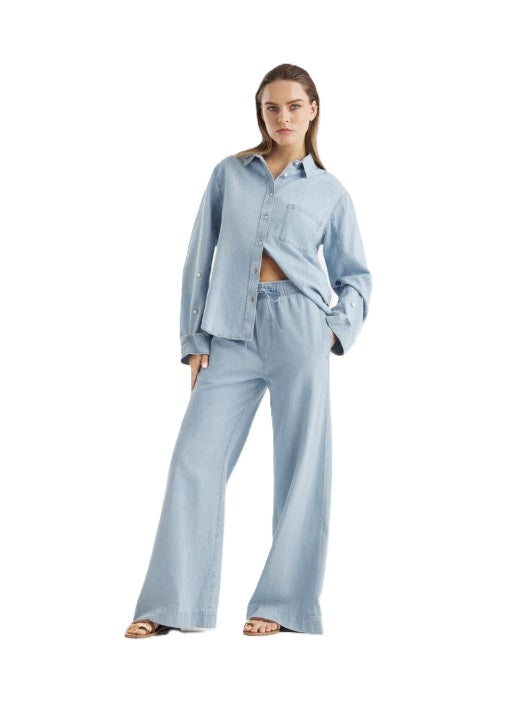 Jeans SO SUE Anna Pants light Denim. Die Anna Pants in Light Blue ist die perfekte Kombination aus Denim-Look und sommerlicher Leichtigkeit. Gefertigt aus feinem Denim Chambray, fühlt sie sich weich, fließend und angenehm kühl auf der Haut an. Die Jeans hat einen Gummibund und einen Tunnelzug zum Justieren. Sie hat Taschen und ein weites lässiges langes Bein.