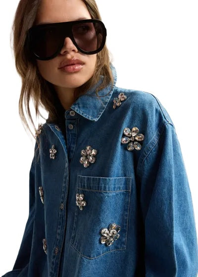 Jeansbluse Essentiel Antwerp KONNECTION RHINESTONE SHIRT in blau mit Glassteinchen auf der Vorderseite. Auf der Rückseite ist die Bluse glockig geschnitten. Sie hat Knopfleiste und eine Brusttasche.