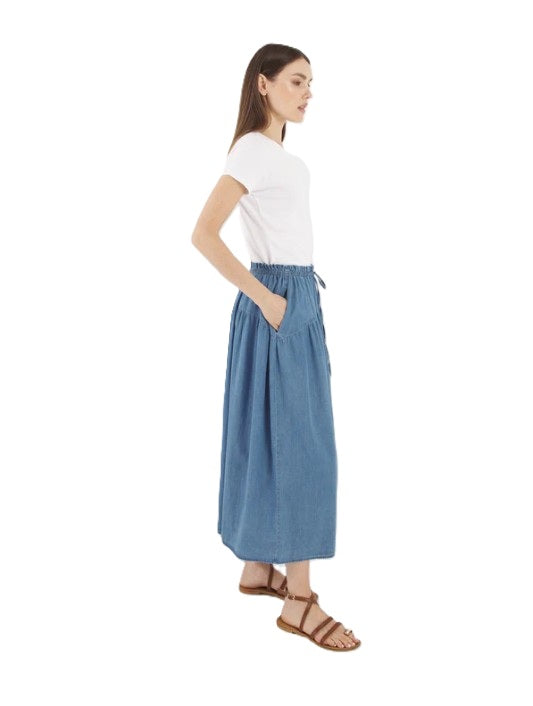 Jeansrock SO SUE Skirt Palma Denim. Der SOSUE Skirt Palma ist ein zeitloser, luftiger Midi-Rock aus 100 % Denim Baumwolle. Der elastische Bund mit kleinem Bindeband vorne sorgt für eine flexible Passform und einen entspannten Look. Durch die leicht ausgestellte Silhouette und die feine Raffung unterhalb des Bunds fällt der Rock besonders schön. Praktische seitliche Eingriffstaschen.