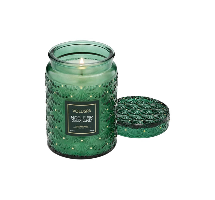 Duftkerze VOLUSPA Noble Fir Garland im dekorativen, geprägten Glasgefäß mit passendem Deckel. Die hochwertige Kokoswachsmischung mit natürlichem Docht verströmt einen festlichen Duft aus Tanne, Rosmarin, Kardamom, Zedernholz, Cashmere-Moschus und Amber.