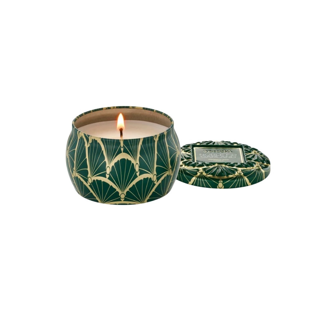 Duftkerze VOLUSPA Noble Fir Garland Mini Tin Candle in dekorativer Metalldose mit geprägtem Deckel. Die hochwertige Kokoswachsmischung mit natürlichem Docht verströmt eine winterliche Duftkomposition aus Tanne, Rosmarin, Kardamom, Zedernholz, Moschus und Amber.