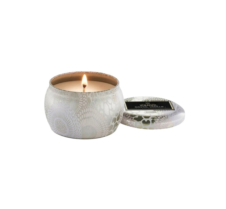 Duftkerze VOLUSPA Santal Vanille Mini Tin Candle in dekorativer Metalldose mit Japonica-Muster und passendem Deckel. Die hochwertige Kokoswachsmischung mit natürlichem Docht verströmt eine warme Duftkomposition aus cremiger Vanille, exotischem Oud und Sandelholz.
