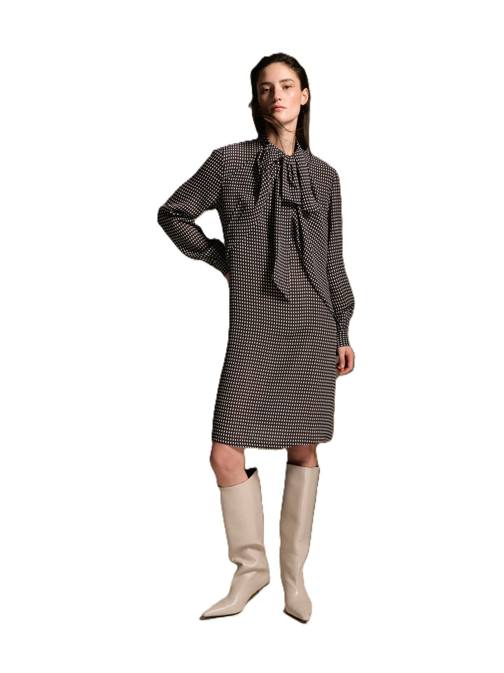 Kleid 0039 Italy Dorothea Dress. Schönes feminines Kleid mit braun/weißen Punkten und geradem Schnitt. Das Kleid ist bis ans Knie geschnitten. Es hat lange Ärmel mit Manschetten und Knopf. Eine angenähte Schluppe am Kragen ist ein besonderes Highlight. Auf der Rückseite befindet sich ein Reißverschluss. 