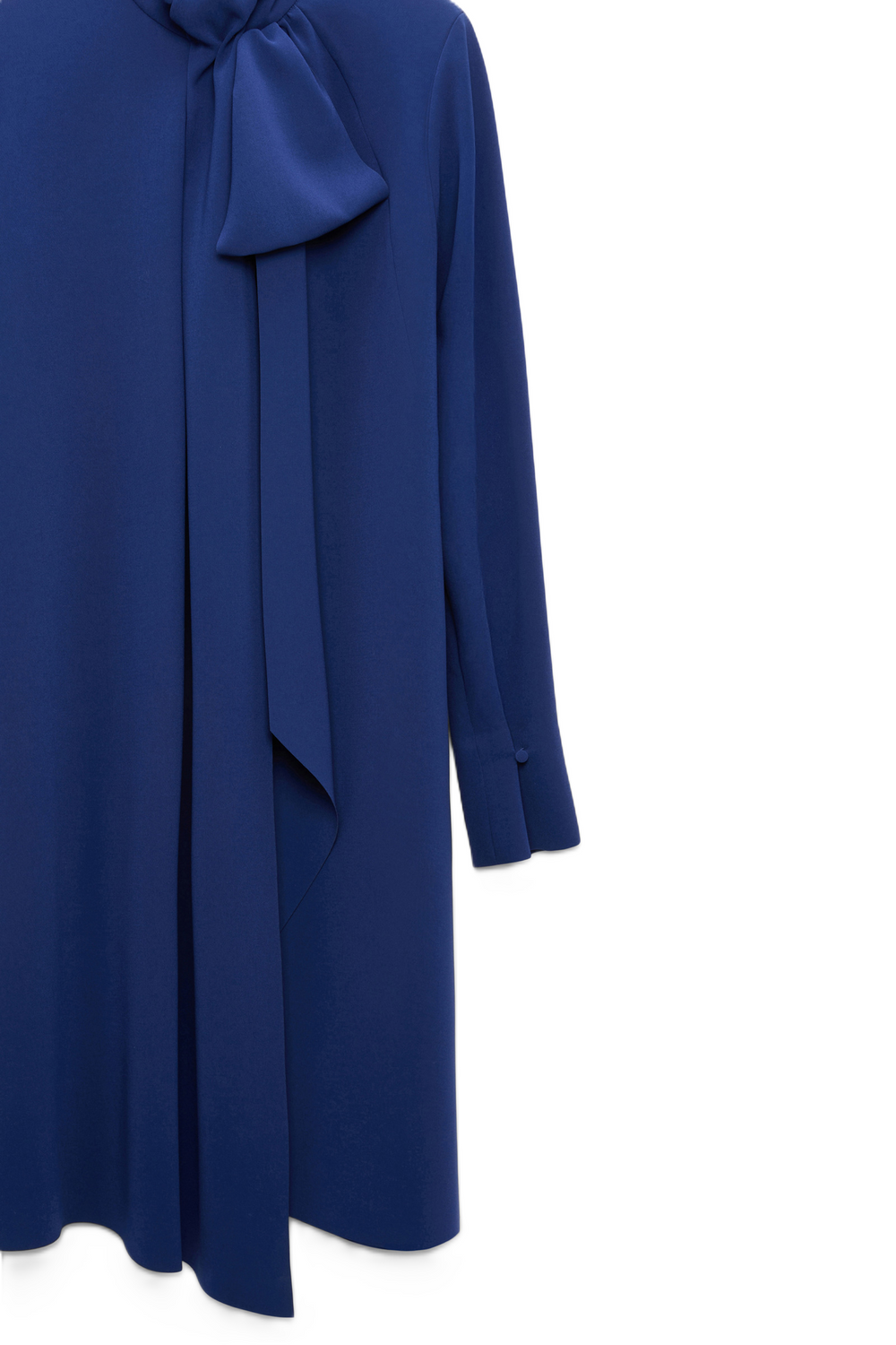 Knielanges Kleid von Dorothee Schumacher aus japanischem Crêpe mit fließender Silhouette und großem Schleifendetail. Es ist blau und hat lange Ärmel.