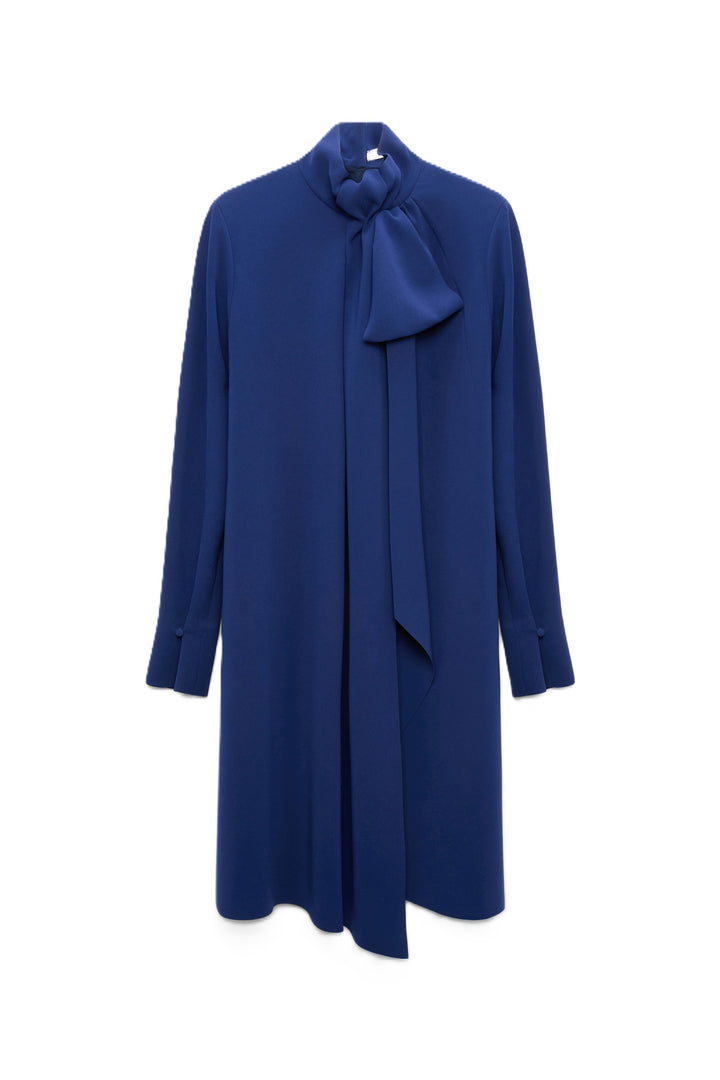 Knielanges Kleid von Dorothee Schumacher aus japanischem Crêpe mit fließender Silhouette und großem Schleifendetail. Es ist blau und hat lange Ärmel.