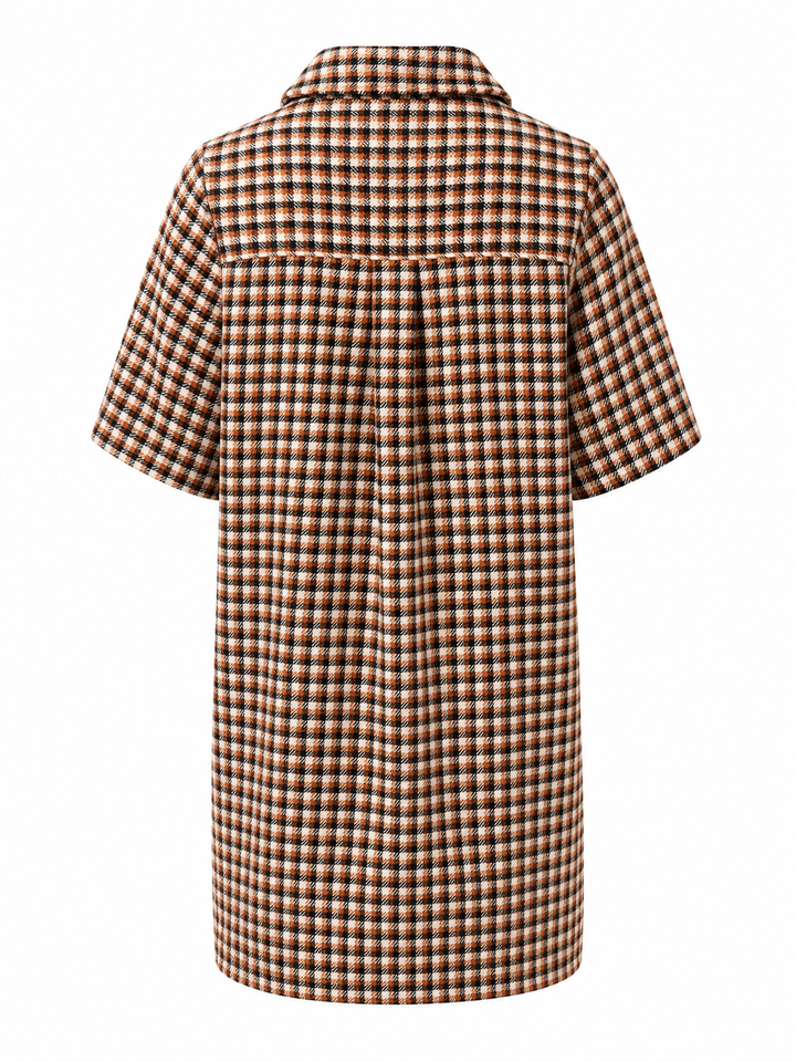 Ein kariertes Minikleid von der Marke  ESSENTIEL Antwerp. Es hat kurze Ärmel und Goldene Knopfverzierungen. Außerdem hat es zwei aufgesetzte Taschen auf Hüfthöhe und einen Polokragen. Es ist in braun beige und schwarztönen kariert und hat einen geraden Schnitt.
