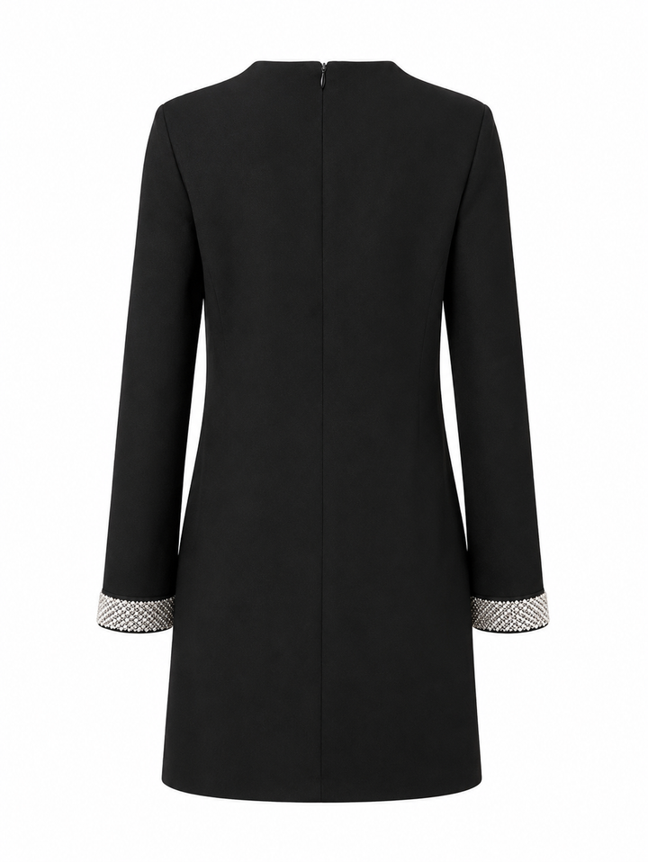 Ein schwarzes Midi Kleid mit Perlenmanschetten. Es hat einen Rundhalsausschnitt und einen Reißverschluss am Rücken.