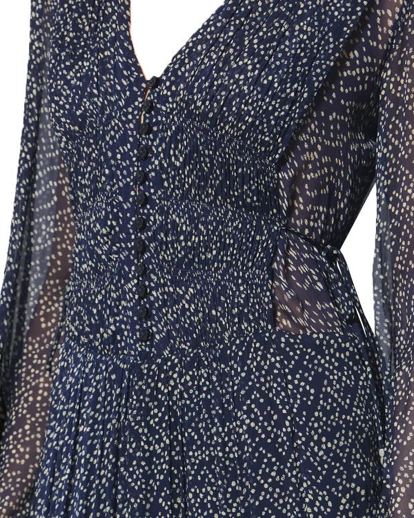 Kleid Isabel Marant BRIANE in blau weiß. Dieses Kleid aus bedrucktem Musselin verbindet romantische Leichtigkeit mit raffinierten Details. Ein eleganter V-Ausschnitt mit schmaler Knopfleiste, lange Puffärmel und ein transparenter Einsatz mit Smokdetails setzen feminine Akzente. Die Taille lässt sich über seitliche Bindebänder individuell anpassen.