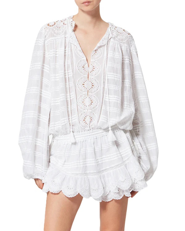 Kleid Isabel Marant PREYA in weiß. Dieses wunderschöne Kleid von Isabel Marant ist aus organischer Baumwolle gefertigt und besticht durch seine florale Spitze mit verspielten Volants. Das Minikleid verfügt über einen Tunika-Ausschnitt mit Kordeln zum Binden und Gummimanschetten am Ärmel. 