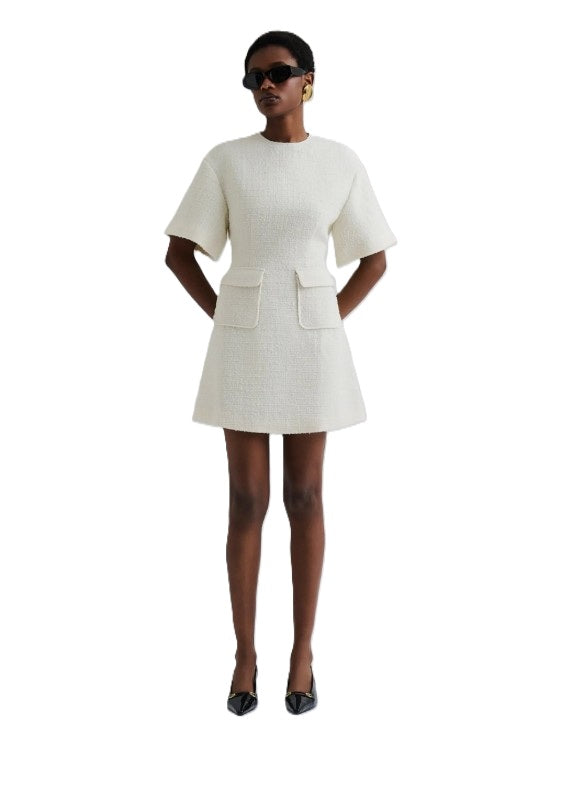 Kleid Malina Rayna Boucle Mini Dress in ecru. Boucle Minikleid mit Taschen. Bezauberndes Kleid mit kurzen Ärmeln und aufgesetzten Taschen. Das Kleid hat einen Rundhalsausschnitt und einen verdeckten Reißverschluss auf der Rückseite.