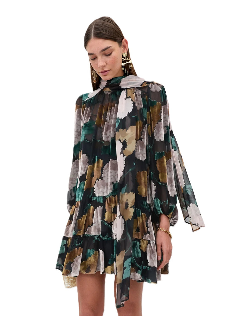 Kleid Rixo Anaya Dress Hydrangea Floral Charcoal. Super schönes feminines Kleid mit romantischem Blumendruck in herbstlichen Farben. Das Kleid hat einen Stehkragen mit Schluppe, mit der man spielen und variieren kann. Es hat eine gerade Form und der Rockteil ist in Volants gearbeitet. An den Ärmeln befinden sich Gummimanschetten