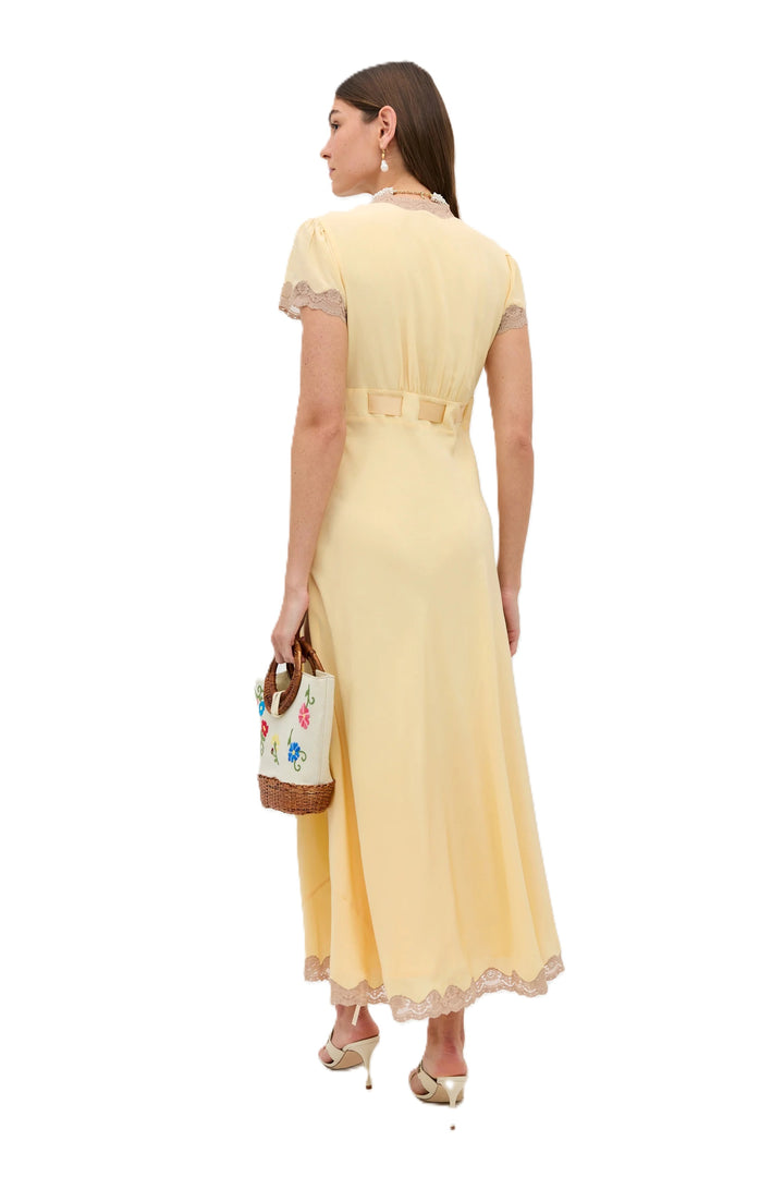 Kleid Rixo Marlice butter yellow in buttergelb. Das Kleid aus leichtem Seiden-Crêpe de Chine überzeugt mit einer eleganten, fließenden Silhouette. Der tiefe V-Ausschnitt, die Empire-Taille mit verstellbarem Satintaillenband und feinen Spitzenborten unterstreichen den femininen Charakter des Designs. Reisverschluss seitlich. 