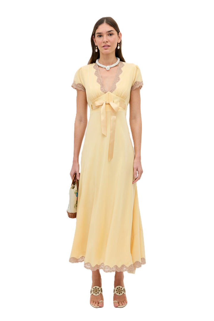 Kleid Rixo Marlice butter yellow in buttergelb. Das Kleid aus leichtem Seiden-Crêpe de Chine überzeugt mit einer eleganten, fließenden Silhouette. Der tiefe V-Ausschnitt, die Empire-Taille mit verstellbarem Satintaillenband und feinen Spitzenborten unterstreichen den femininen Charakter des Designs. Reisverschluss seitlich. 