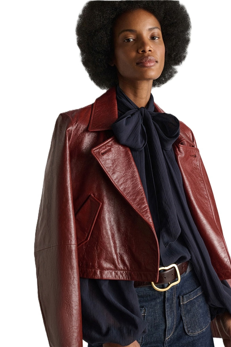 Lederjacke Dorothee Schumacher BROKEN SHINE Jacket in marsala. Die aus weichem Lammleder gefertigte, kastenförmige Jacke vermittelt mit ihrem mattglänzenden Finish einen modernen Vintage-Look. Der boxy Schnitt hat ausgestellte Ärmel und schräge Eingriffstaschen. Der Zweireiher hat ein Revers und einen Kragen und Riegeldetails.