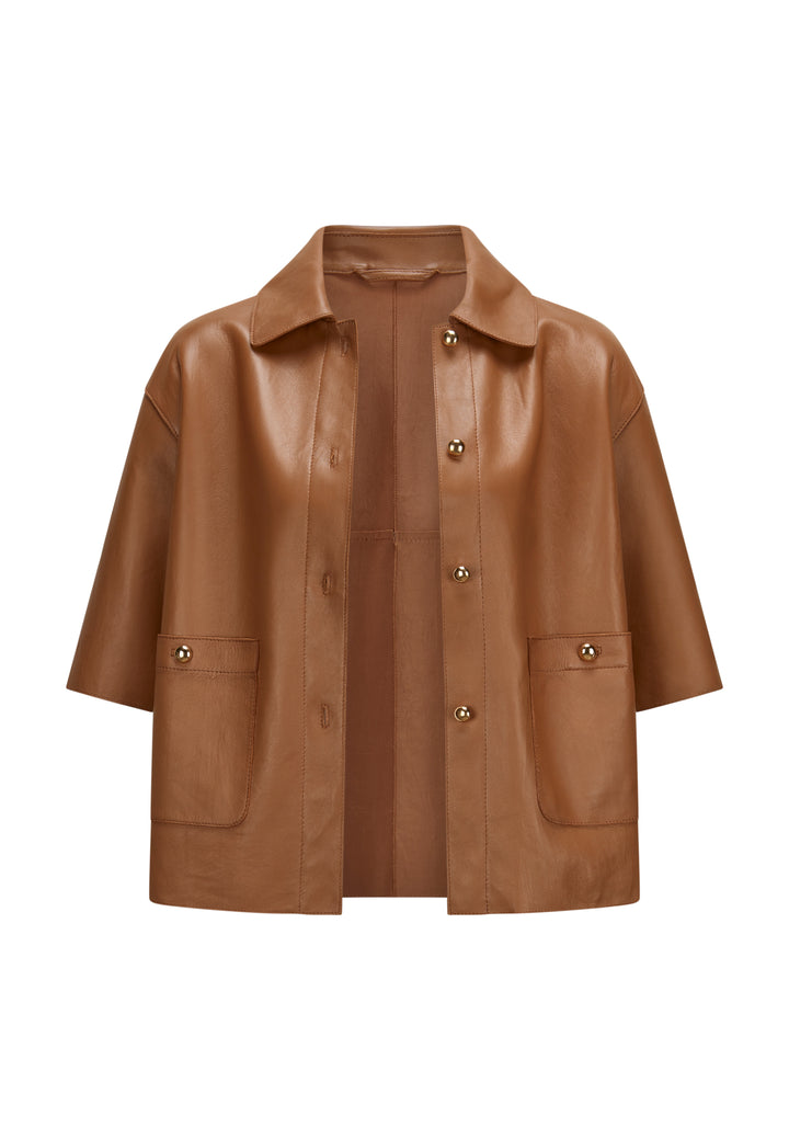 Jacke Milestone MSBetty in cognac. Wunderschöne Jacke aus feinem Lamm Nappa. Die Jacke ist bondiert mit tonigem Lycra Jersey. Sie ist geschnitten wie ein kurzes Hemd mit Knöpfen. Die Form ist gerade. Die Jacke hat einen Hemdkragen und einen Knopfverschluss. Ebenso zwei aufgesetzte Taschen mit Knopf. Die Ärmel sind kurz und die Schultern leicht überschnitten. An der Seitennaht befindet sich ein kleiner Schlitz. 