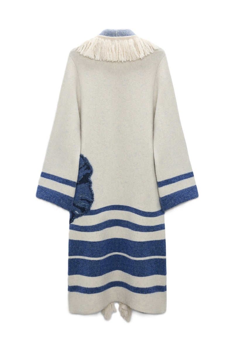 Mantel Dorothee Schumacher POPPY GARDEN coat in blau und ecru. Der Jacquard-Strickmantel hat ein blockartiges Streifenmuster und ein XL-Mohnblumenmotiv an der Seite. Der Mantel ist offen und hat weich fallende Fransen. An den Seitennähten befinden sich Taschen.