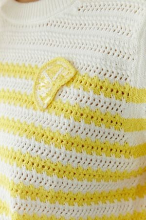 Pullover Oui. Hübscher Pullover in zweifarbigem Streifenprint in gelb und weiß. Der Pullover ist grob und durchlöchert gestrickt und hat einen Rundhalsausschnitt. Er hat einen kurzen Ärmel und ist kürzer geschnitten. Paillettenzitrone auf der Brust. 