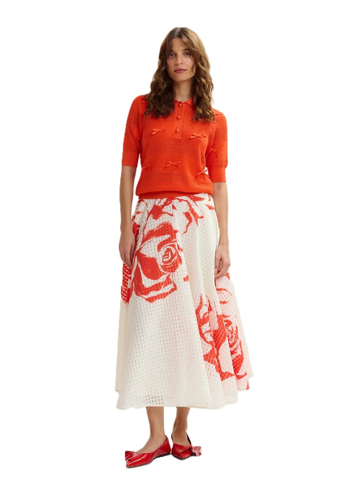 Rock Essentiel Antwerp JANGO MAXI SKIRT in weiß und orange. Dieser Midirock mit tailliertem Bund fällt in eine weite A-Linie, die durch Kellerfalten und verstreute Blumenakzente betont wird. Er ist aus einem glänzenden recycelten Polyestermischgewebe gefertigt und verfügt über praktische Taschen für zusätzliche Funktionalität. Der Rock hat einen hohen Bund und einen verdeckten Reißverschluss.