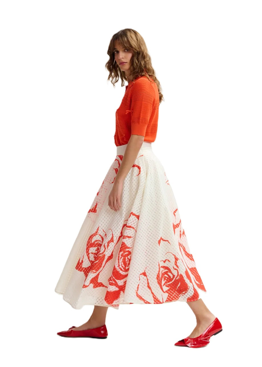 Rock Essentiel Antwerp JANGO MAXI SKIRT in weiß und orange. Dieser Midirock mit tailliertem Bund fällt in eine weite A-Linie, die durch Kellerfalten und verstreute Blumenakzente betont wird. Er ist aus einem glänzenden recycelten Polyestermischgewebe gefertigt und verfügt über praktische Taschen für zusätzliche Funktionalität. Der Rock hat einen hohen Bund und einen verdeckten Reißverschluss.