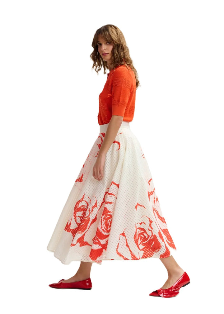 Rock Essentiel Antwerp JANGO MAXI SKIRT in weiß und orange. Dieser Midirock mit tailliertem Bund fällt in eine weite A-Linie, die durch Kellerfalten und verstreute Blumenakzente betont wird. Er ist aus einem glänzenden recycelten Polyestermischgewebe gefertigt und verfügt über praktische Taschen für zusätzliche Funktionalität. Der Rock hat einen hohen Bund und einen verdeckten Reißverschluss.
