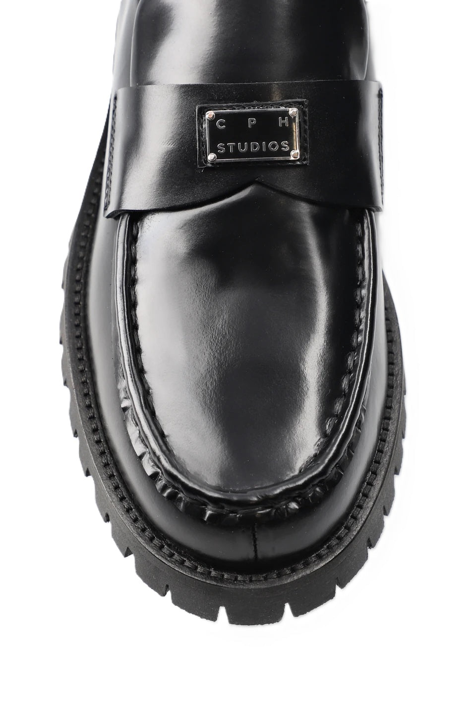 Schuh Copenhagen Studios CPH848 in schwarz. Dieser Loafer ist schmal geschnitten und hat eine glatte, klare Form. Der V-förmige Steg, das glänzende, gebürstete Finish und das Logopatch aus Metall auf der Zunge machen den besonderen Look aus. Das Leder ist sehr weich und der Schuh sehr angenehm zu tragen. 