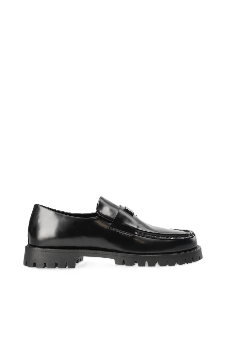 Schuh Copenhagen Studios CPH848 in schwarz. Dieser Loafer ist schmal geschnitten und hat eine glatte, klare Form. Der V-förmige Steg, das glänzende, gebürstete Finish und das Logopatch aus Metall auf der Zunge machen den besonderen Look aus. Das Leder ist sehr weich und der Schuh sehr angenehm zu tragen. 