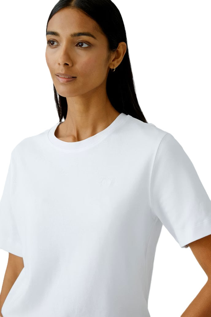 Shirt Oui SVEHA Cloud dancer. Besonderes T-Shirt SVEHA in schwerer, blickdichter Baumwolle. Das Shirt versprüht einen sportlichen Look aund hat einen hohen Tragekomfort. Als kleines Highlight ist ein kleines Herzlogo auf der Brust eingestickt. Das Shirt ist gerade und lässig geschnitten