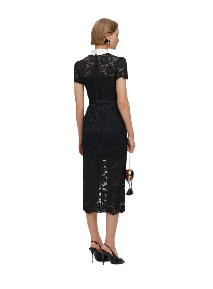 Kleid Self-Portrait in schwarz. Dieses elegante Midikleid begeistert mit einer figurbetonten Silhouette und einer aufwendig gearbeiteten Blumenspitze. Der kontrastreiche Kragen mit dekorativer Schleife und funkelnden Knöpfen verleiht dem Design eine edle Ausstrahlung, während der abnehmbare Gürtel die Taille stilvoll betont. 