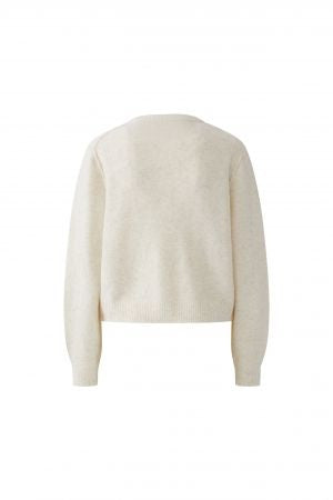 Strickjacke Oui Ilaya in ecru. Kuschelig weiche Garnmischung mit glatt gestrickter Oberfläche und markanten Outside Seams. Lässiger, leicht verkürzter Schnitt mit zurückversetzter Schulternaht. Rundhalsausschnitt, lange Ärmel und Knopfleiste mit Knöpfen in Hornoptik.